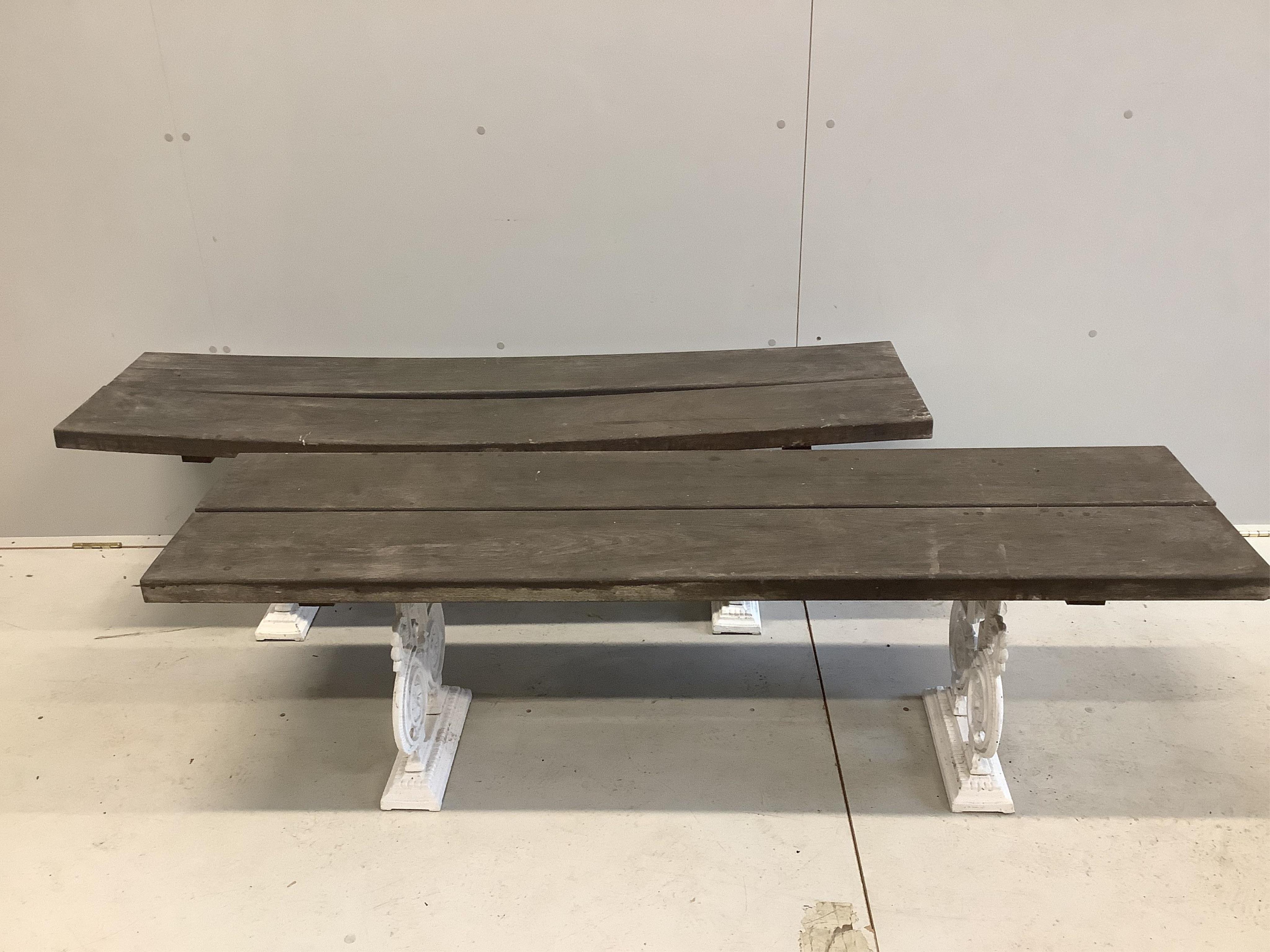 A Victorian style slatted cast metal rectangular garden table, width 151cm, depth 91cm, height 72cm, and a pair of matching benches. Condition - fair